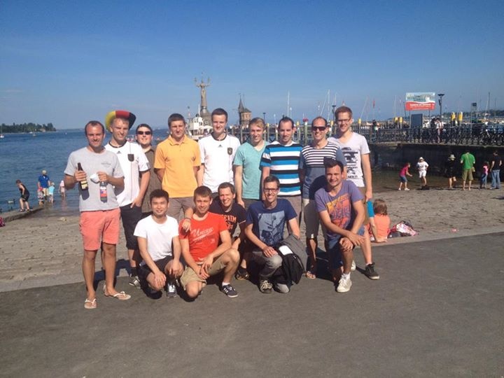 Eine Gruppe Studierender posiert an einer Konstanzer Hafenpromenade für ein Gruppenbild.