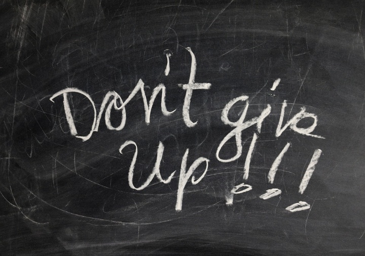 Auf einer Tafel steht mit Kreide geschrieben "Don't give up"