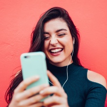 Young happy woman doing video call with smart phone